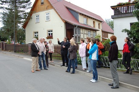 Besuch einer brandenburgischen Delegation, Bild: Diskussion angesichts des Kulturhauses Pfersdorf
